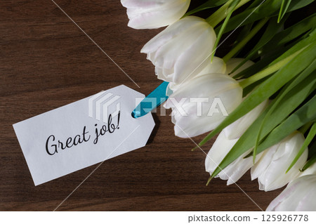 Tag with Great job message attached to fresh white tulips on wooden background ideal for celebrating achievement recognition and positive encouragement or reward Tag with Great job message attached to fresh white tulips on wooden background ideal for celebrating achievement recognition and positive encouragement or reward 125926778