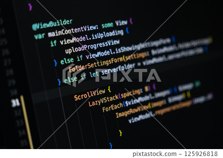 Close-up of Swift programming code on a computer screen showing mobile app interface structure 125926818