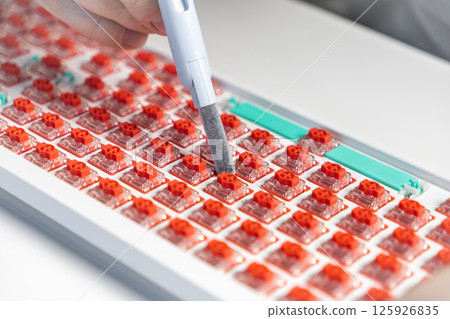 Mechanical keyboard switch being cleaned with soft brush tool during custom build process Mechanical keyboard switch being cleaned with soft brush tool during custom build process 125926835