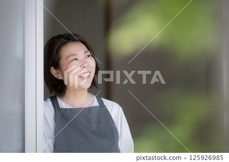 A housewife-like woman looking out the window Lifestyle and second life 125926985