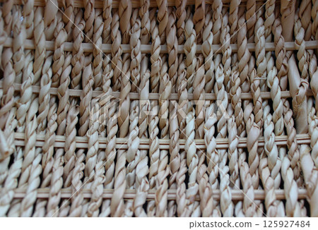 Handmade craft. Texture of thin wooden twigs woven in braids 125927484