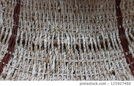 The bottom of a round craft basket woven from braided willow twigs The bottom of a round craft basket woven from braided willow twigs 125927488