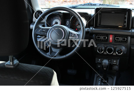 View from behind the driver's seat of the switched off instruments on the central panel of the car View from behind the driver's seat of the switched off instruments on the central panel of the car 125927515