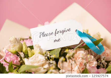 apology bouquet with a heartfelt "please forgive me" card attached by a blue ribbon, featuring delicate pastel flowers on a soft pink background apology bouquet with a heartfelt "please forgive me" card attached by a blue ribbon, featuring delicate pastel flowers on a soft pink background 125927574