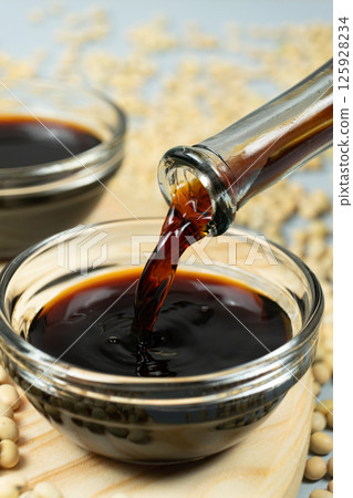 Close-up of the process of pouring soy sauce into a saucepan. 125928234
