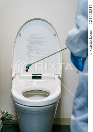 Cleaning worker disinfecting the toilet 125928816