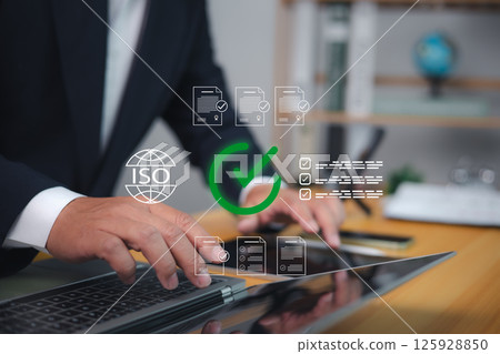 Quality control, Businessman using laptop with ISO certification, Document approval, and compliance management concept for international standard assurance and business process improvement. Quality control, Businessman using laptop with ISO certification, Document approval, and compliance management concept for international standard assurance and business process improvement. 125928850