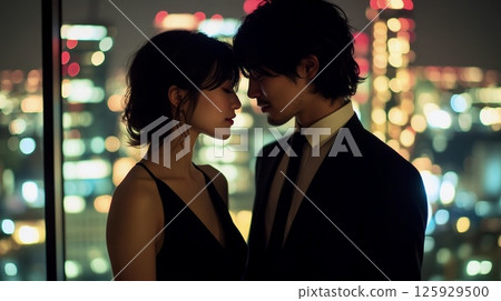 A man and a woman standing together with the night view in the background 125929500