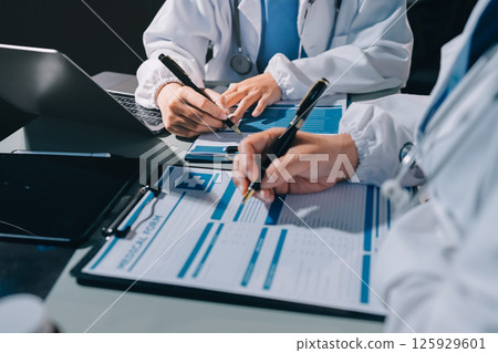 Male and female doctors are having a meeting in a hospital room. 125929601