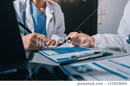 Male and female doctors are having a meeting in a hospital room. Male and female doctors are having a meeting in a hospital room. 125929604
