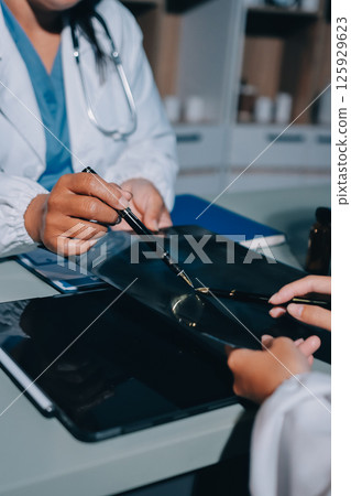 Male and female doctors are having a meeting in a hospital room. Male and female doctors are having a meeting in a hospital room. 125929623