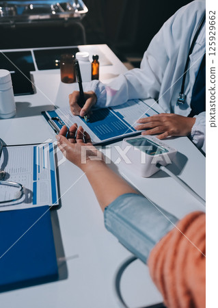 Nurse measuring blood pressure of elderly woman at table, closeup. Assisting senior generation Nurse measuring blood pressure of elderly woman at table, closeup. Assisting senior generation 125929662