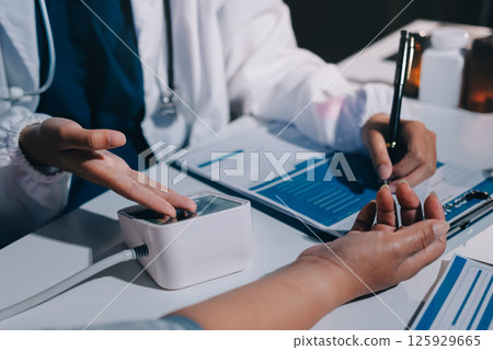 Nurse measuring blood pressure of elderly woman at table, closeup. Assisting senior generation 125929665