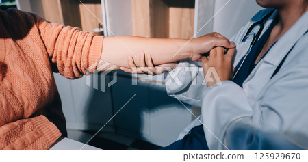 Orthopedist examining patient in hospital Orthopedist examining patient in hospital 125929670