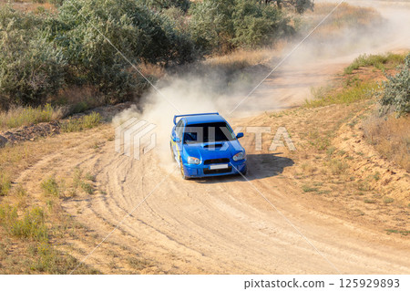 Blue Rally Car Turns with Dust Blue Rally Car Turns with Dust 125929893