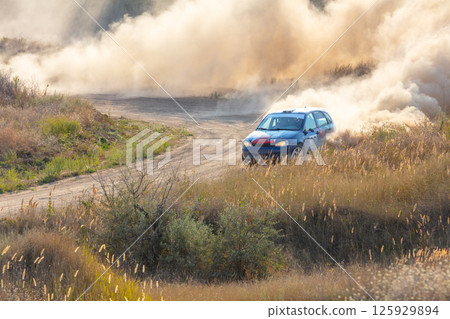 Rally Car Makes Dust on a Turn on a Dirt Road Rally Car Makes Dust on a Turn on a Dirt Road 125929894