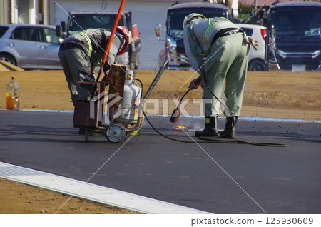 Paving work being done on a walkway in a housing development 125930609