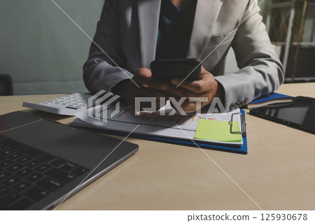 Working from home, Closeup business woman using laptop computer and analyzing financial report. 125930678