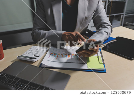 Working from home, Closeup business woman using laptop computer and analyzing financial report. 125930679