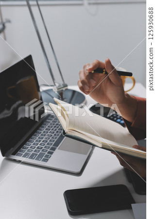 Working from home, Closeup business woman using laptop computer and analyzing financial report. Working from home, Closeup business woman using laptop computer and analyzing financial report. 125930688