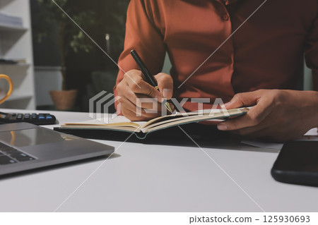Working from home, Closeup business woman using laptop computer and analyzing financial report. Working from home, Closeup business woman using laptop computer and analyzing financial report. 125930693
