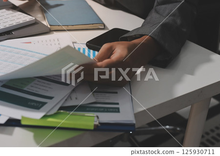 Working from home, Closeup business woman using laptop computer and analyzing financial report. Working from home, Closeup business woman using laptop computer and analyzing financial report. 125930711