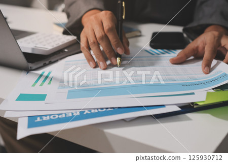 Working from home, Closeup business woman using laptop computer and analyzing financial report. 125930712