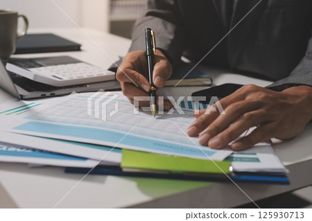 Working from home, Closeup business woman using laptop computer and analyzing financial report. Working from home, Closeup business woman using laptop computer and analyzing financial report. 125930713