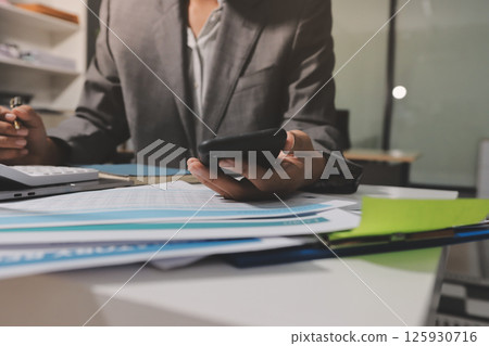 Working from home, Closeup business woman using laptop computer and analyzing financial report. 125930716