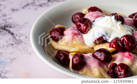 macro photo of cherry dumplings covered with sour cream with steam in a plate on a white mar macro photo of cherry dumplings covered with sour cream with steam in a plate on a white mar 125930961