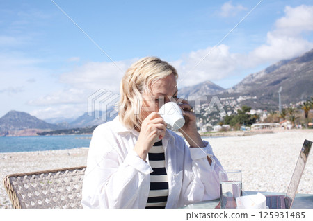 mature woman working outside in caffe on beach coast, lifestyle people concept 125931485