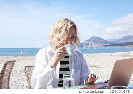 mature woman working outside in caffe on beach coast, lifestyle people concept 125931488