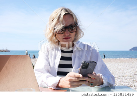 mature woman working outside in caffe on beach coast, lifestyle people concept 125931489