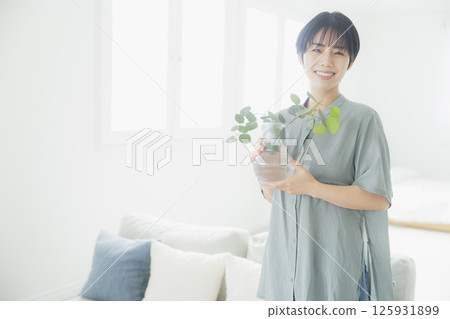 拿著葉子植物的婦女 125931899
