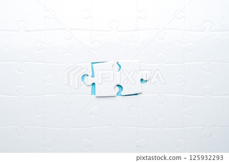 Concept for problem-solving, teamwork, solutions, or missing connections. White jigsaw puzzle on a vibrant blue background with one missing piece. Minimalist composition with copy space. Concept for problem-solving, teamwork, solutions, or missing connections. White jigsaw puzzle on a vibrant blue background with one missing piece. Minimalist composition with copy space. 125932293
