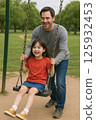 Parents and children playing on a swing 125932453