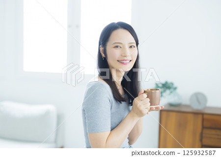 年輕女子在房間裡喝咖啡 125932587