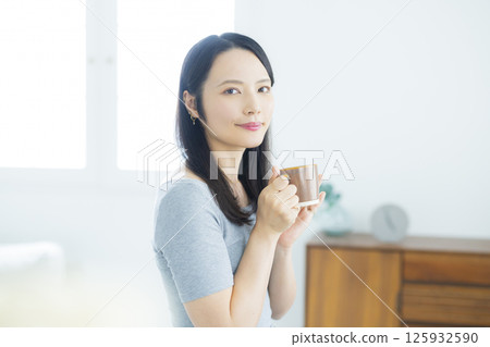 年輕女子在房間裡喝咖啡 125932590