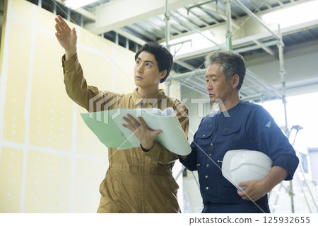 Site supervisors discussing plans at the site Site supervisors discussing plans at the site 125932655