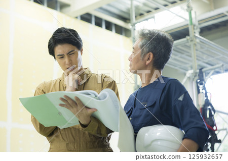 Site supervisors discussing plans at the site 125932657