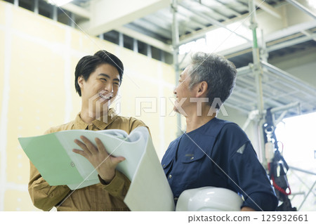 Site supervisors discussing plans at the site 125932661