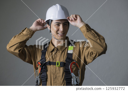 身穿全套安全帶的男性工人 身穿全套安全帶的男性工人 125932772