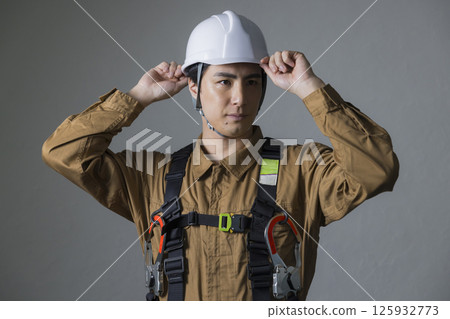 身穿全套安全帶的男性工人 身穿全套安全帶的男性工人 125932773