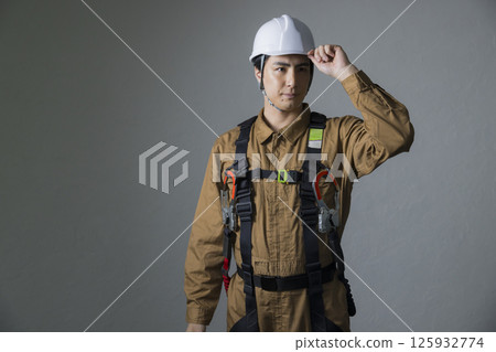 Male worker wearing a full harness 125932774