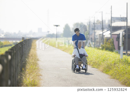 Senior men riding a wheelchair Senior men riding a wheelchair 125932824