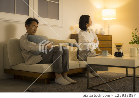 A middle-aged couple arguing in the living room at night 125932887