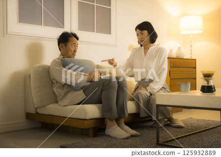 一對中年夫婦晚上在客廳爭吵 一對中年夫婦晚上在客廳爭吵 125932889