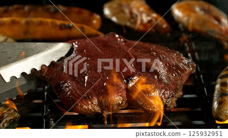 Close-up of Beef Steak on a Grill with Roaring Flames Close-up of Beef Steak on a Grill with Roaring Flames 125932951