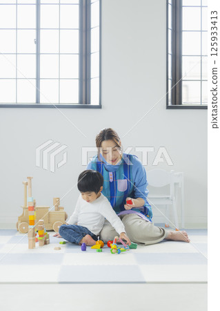 一個玩積木的孩子和一個穿著圍裙的女人 125933413