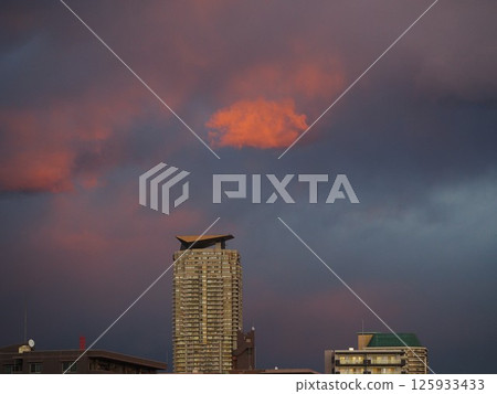 Sunset clouds floating above a skyscraper apartment building Sunset clouds floating above a skyscraper apartment building 125933433